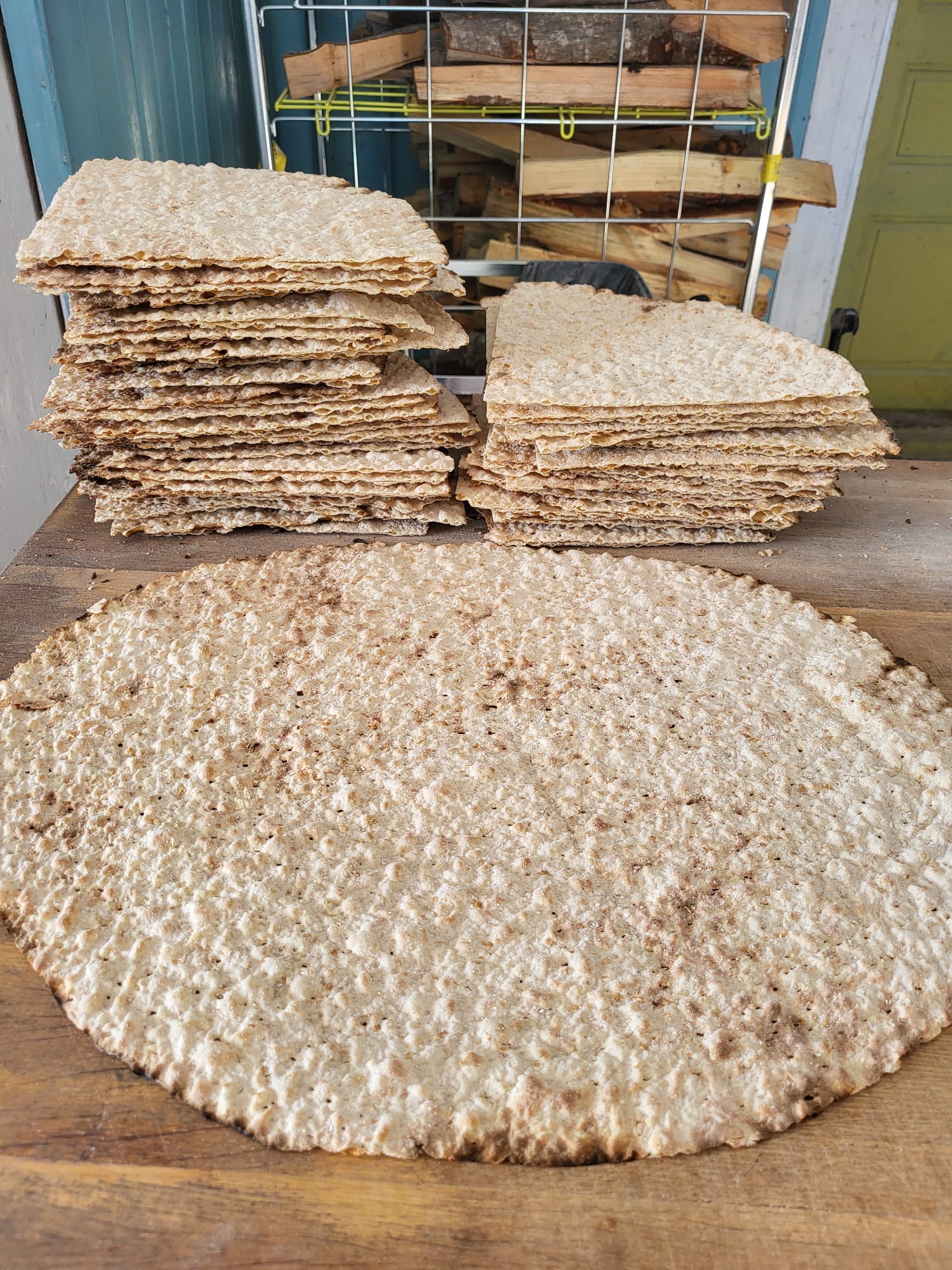 Nybakat tunnbröd – ett helt runt bröd och staplar av skurna bitar