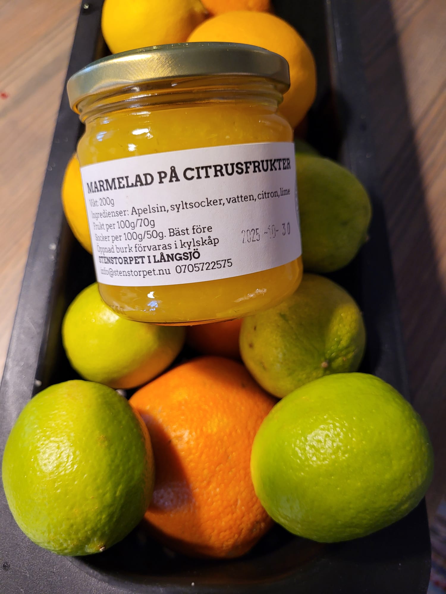 Hemkokt citrusmarmelad i glasburk omgiven av färska citrusfrukter